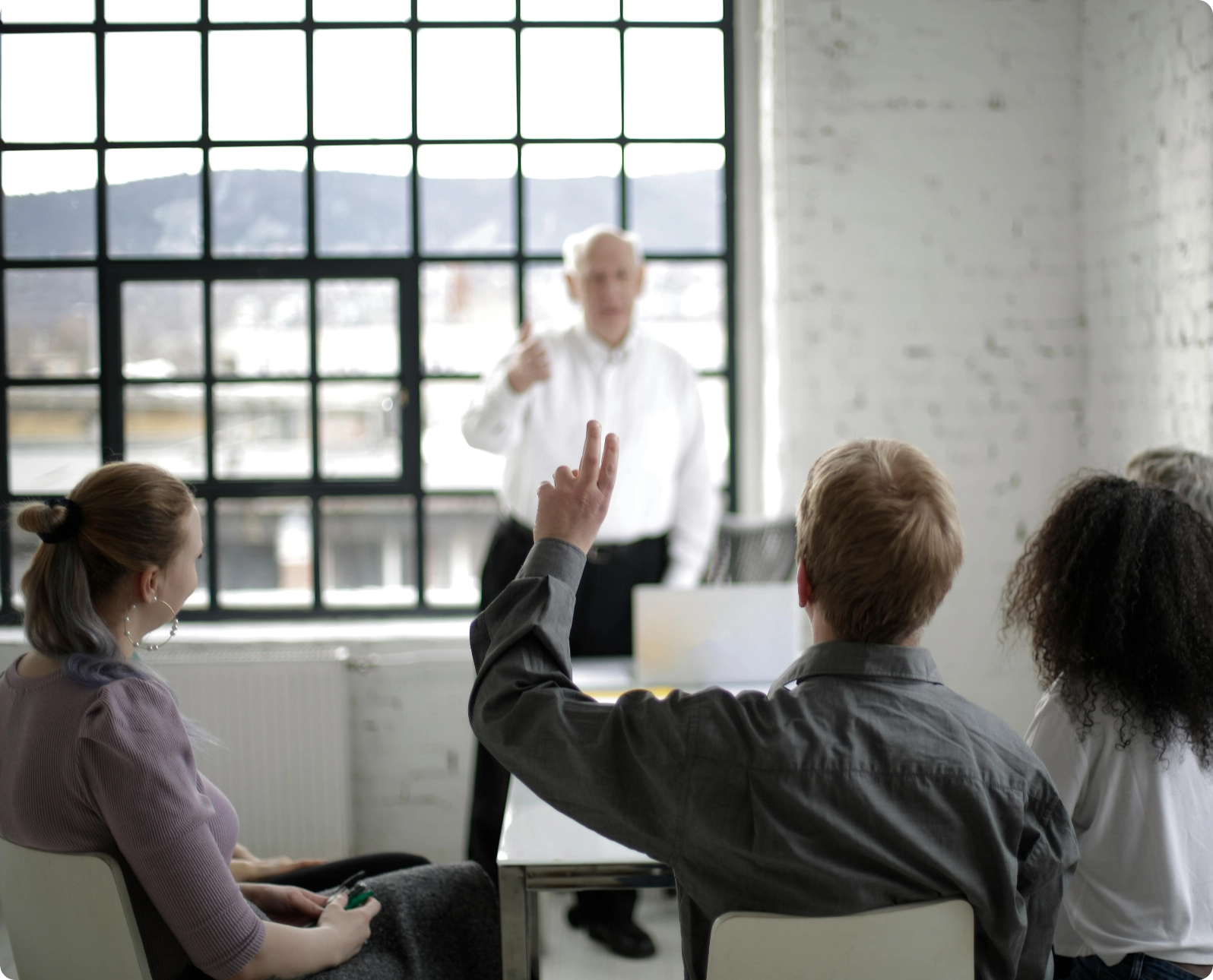 A person in class raising hand to ask a question